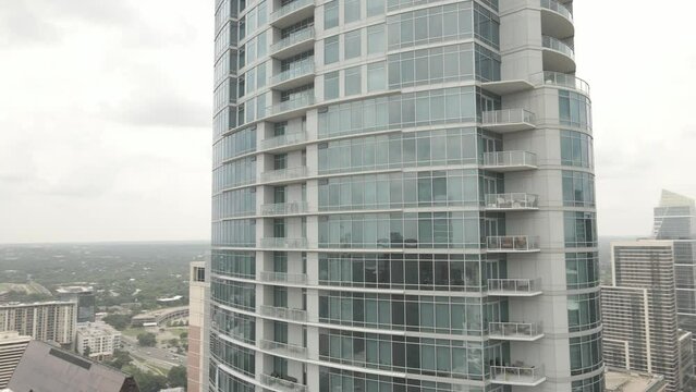 Rotating drone footage of urban skyscraper tower with glass exterior in Austin city, Texas