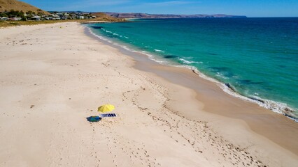 Fototapeta na wymiar Beach umbrella on the white sands of a sunny beach with foamy waves on a sunny day