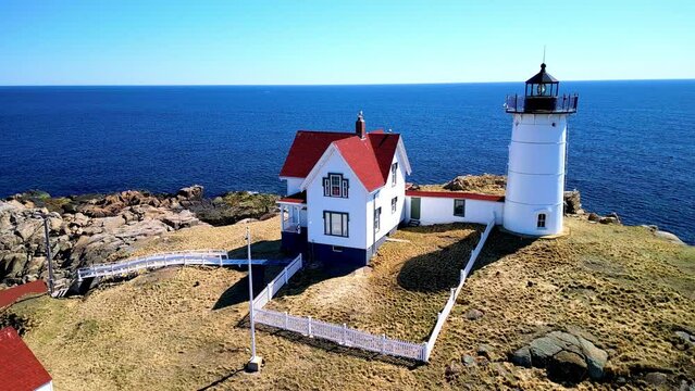 Aerial view over Nubble Lighthouse over rocky cliff vy the sea in York, Maine