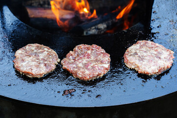 Cooking cutlets on fire and coals. The process of making products from minced meat for a burger. Close up