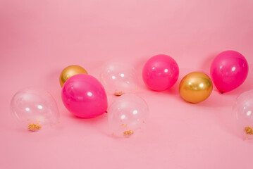 Group of multicolored transparent, pink and gold balloons lying on the floor in the house for Valentine's Day, Birthday, holiday concept
