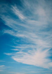 Vertical photo of white clouds on blue sky.