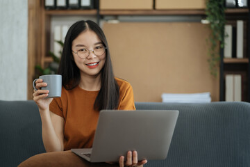 Fototapeta premium Female asian sitting at the desk, looking to camera.