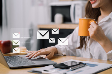 Woman looking for laptop and thinking businessman reading emails on laptop in office.
