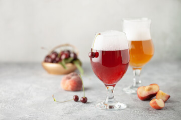 Boozy Refresing Cold Hard Cherry Cider and peach radler in a Pint Glass  on the table. Copy space