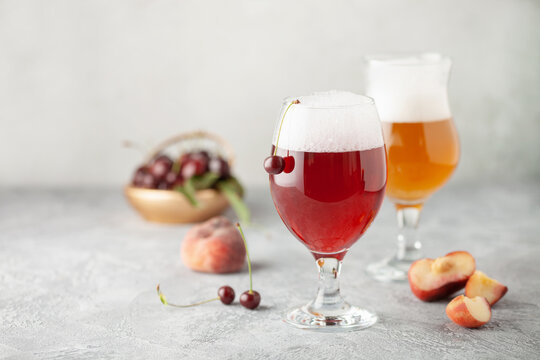 Boozy Refresing Cold Hard Cherry Cider and peach radler in a Pint Glass  on the table. Copy space