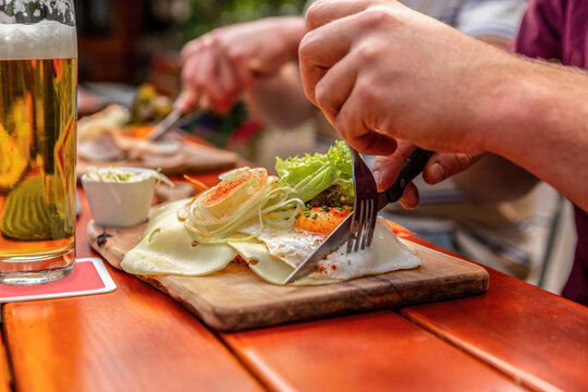 Close-up of a person eating a typical bavarian lunch at a beer garden in summer outdoors