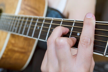 Close up of guitarist hand playing guitar. Chord F