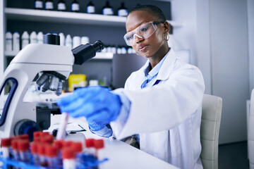 Blood test, microscope and science woman in laboratory for cancer research, medical analysis and...