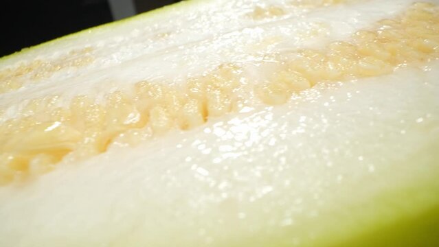 Half Wax Gourd macro video showcases the intricate details of this unique fruit. With a probe lens, it reveals the gourd's smooth waxy skin, delicate seeds, and vibrant green flesh. 4K HDR
