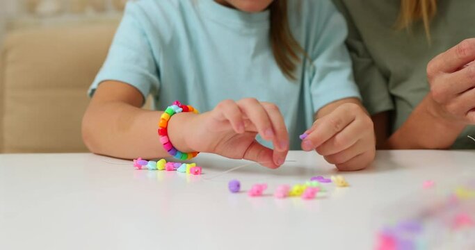 Process of making a bracelet from a thread and colored beads