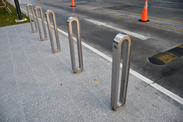 Aluminum Bicycle parking rack or bicycle stand near the road side with bicycle sign,  a device to which bicycles can be securely attached for parking purpose . modern style for city.