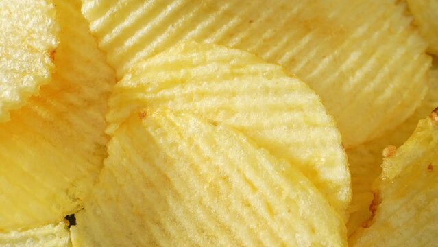 Captivating macro video showcases the irresistible allure of wavy potato chips. The probe lens reveals intricate ripples, enhancing their crunchy texture and savory essence. A mouthwatering spectacle
