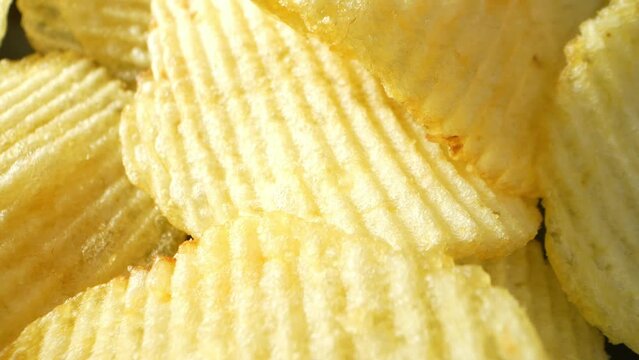Captivating macro video showcases the irresistible allure of wavy potato chips. The probe lens reveals intricate ripples, enhancing their crunchy texture and savory essence. A mouthwatering spectacle
