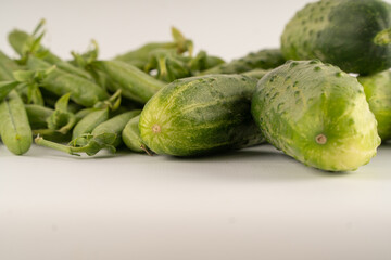 Green peas and cucumbers. Green vegetables on a white background