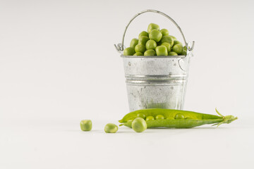 Conceptual presentation of food. Green peas in a small bucket, natural and healthy food, farm
