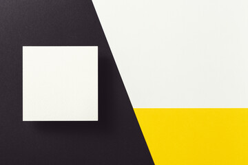 White business card on black, yellow and white background.