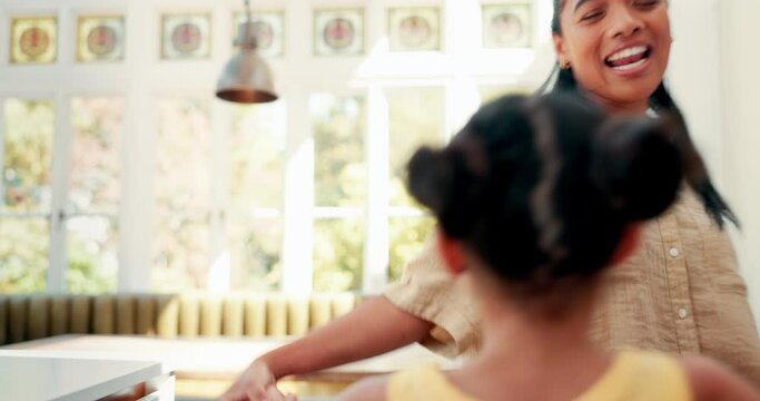 Kitchen, bonding and mom dancing with her child to music, song or album for having fun together. Happy, goofy and young mother singing and doing a dance to a playlist with her girl kid at family home