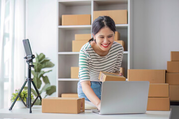 Fototapeta na wymiar Starting Small business entrepreneur SME freelance, Portrait young woman working at home office, BOX, smartphone, laptop, online, marketing, packaging, delivery, b2b, SME, e-commerce concept..