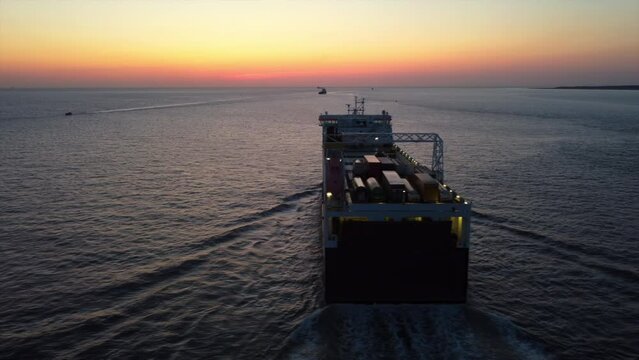 Aerial drone vew of cargo boat near port of Liverpool Great Britain at sunset, slow motion