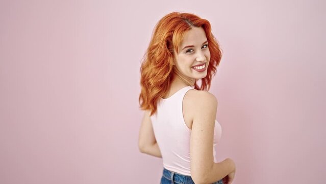Young redhead woman smiling confident standing over isolated pink background