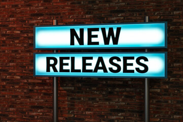 Obraz premium New releases. Black letters on a blue illumintaed light box, red brick wall. Update, new ersion, business, product, software, process, announcement, marketing. 3D illustration