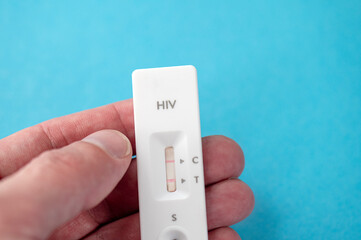 Person holding Express HIV test with positive result - obrazy, fototapety, plakaty