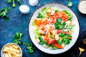 Gourmet Caesar salad with salted salmon, iceberg  lettuce, croutons, parmesan cheese with caesar...