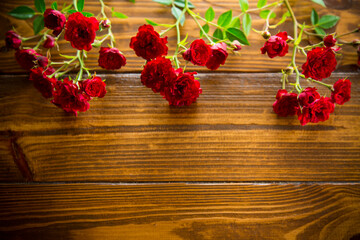 Fototapeta premium bouquet of red small roses, on a wooden background.