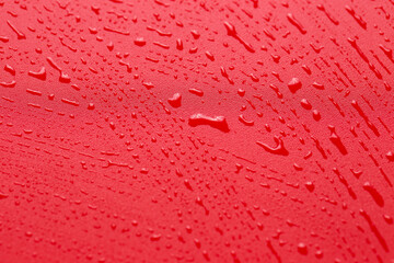 Red waterproof cloth covered with water drops