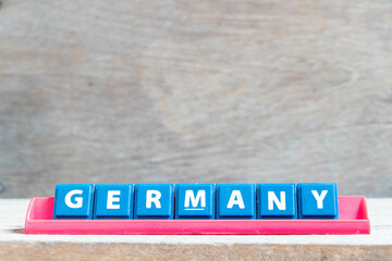 Tile alphabet letter with word germany in red color rack on wood background