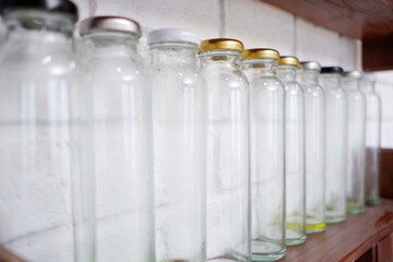 Glass bottles arranged on a wooden shelf.