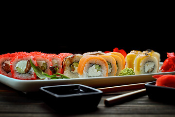 Appetizing sushi rolls in assortment. Soy sauce, ginger