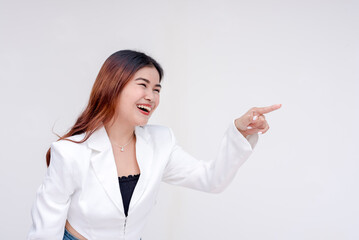 A playful young woman laughingly pointing and facing someone off camera on the right side. Isolated on a white background