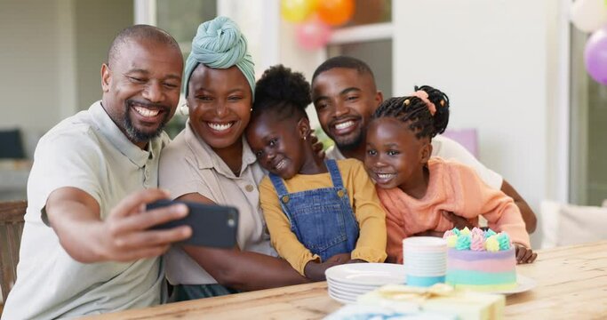 Black family, selfie and birthday of children with parents to celebrate with cake and a smile. African woman, men and happy kids at home for a picture, quality time and bonding or fun at a party