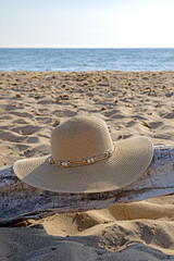 Fototapeta na wymiar Straw hat on the beach. Beach holiday concept.