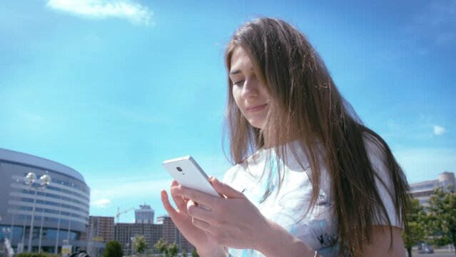 Close-up of Woman Using Phone Outdoors, Reading Messages from Friends, and Browsing Online Shops for Shopping