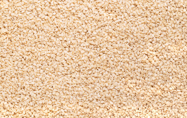 Hulled white sesame seeds, surface, from above. Sesamum indicum, also called benne. Common ingredient in cuisines around the world, with nutty flavor and one of the highest oil content of any seed.