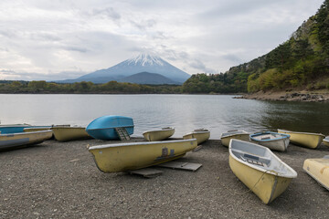 Fototapeta na wymiar boats at Shoji lake shore with mount Fuji or Fujisan background
