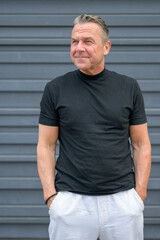 Portrait of a senior man with both hands in his pants