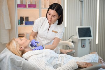 Obraz premium Beautician performing injection on client neck area