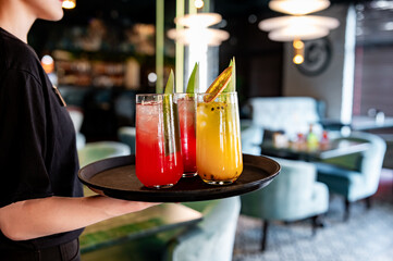 glasses alcohol cocktail set on a waiter tray in bar