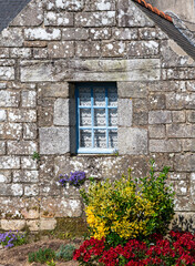 window in a historic stone house in the old center of the village Locronan in Brittany, France