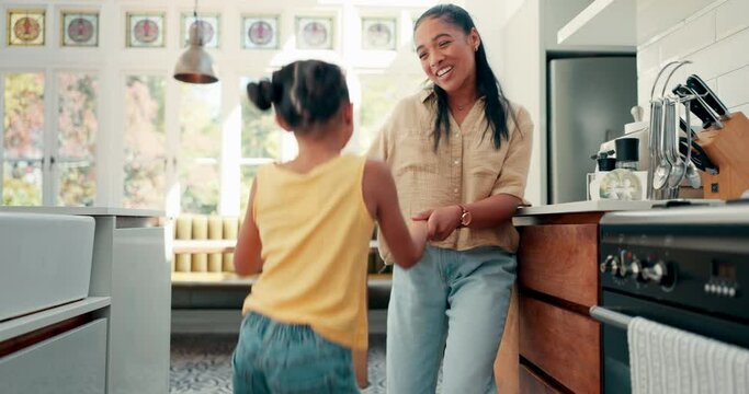 Playful, dance and mother with her kid in the kitchen jumping to music, playlist or radio at home. Happy, goofy and young mom singing and dancing to song or album with girl kid at their family house.