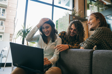 Curly haired male person told how simple and stupid mistake his brunette female colleague did. She is holding her forehead, wondering and laughing