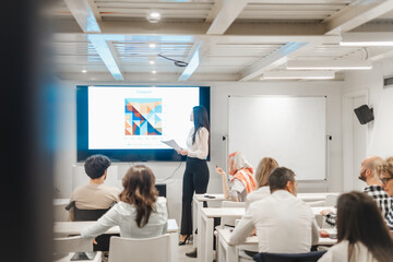 Businesswoman giving speech during a meeting. Multicultural team discussing statistics at modern classroom
