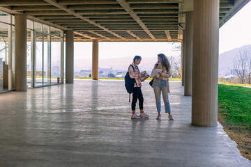 Girls holding books and talking at the school yard