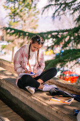 Gorgeous brunette girl using calculator while writing math homework after school