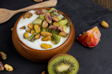fresh green yogurt with pieces of kiwi and pistachios