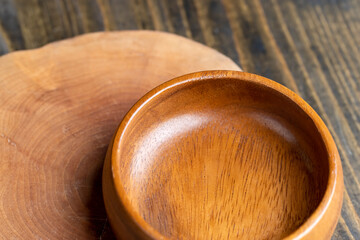 Wooden bowl on wooden table, empty round bowl for groceries and food